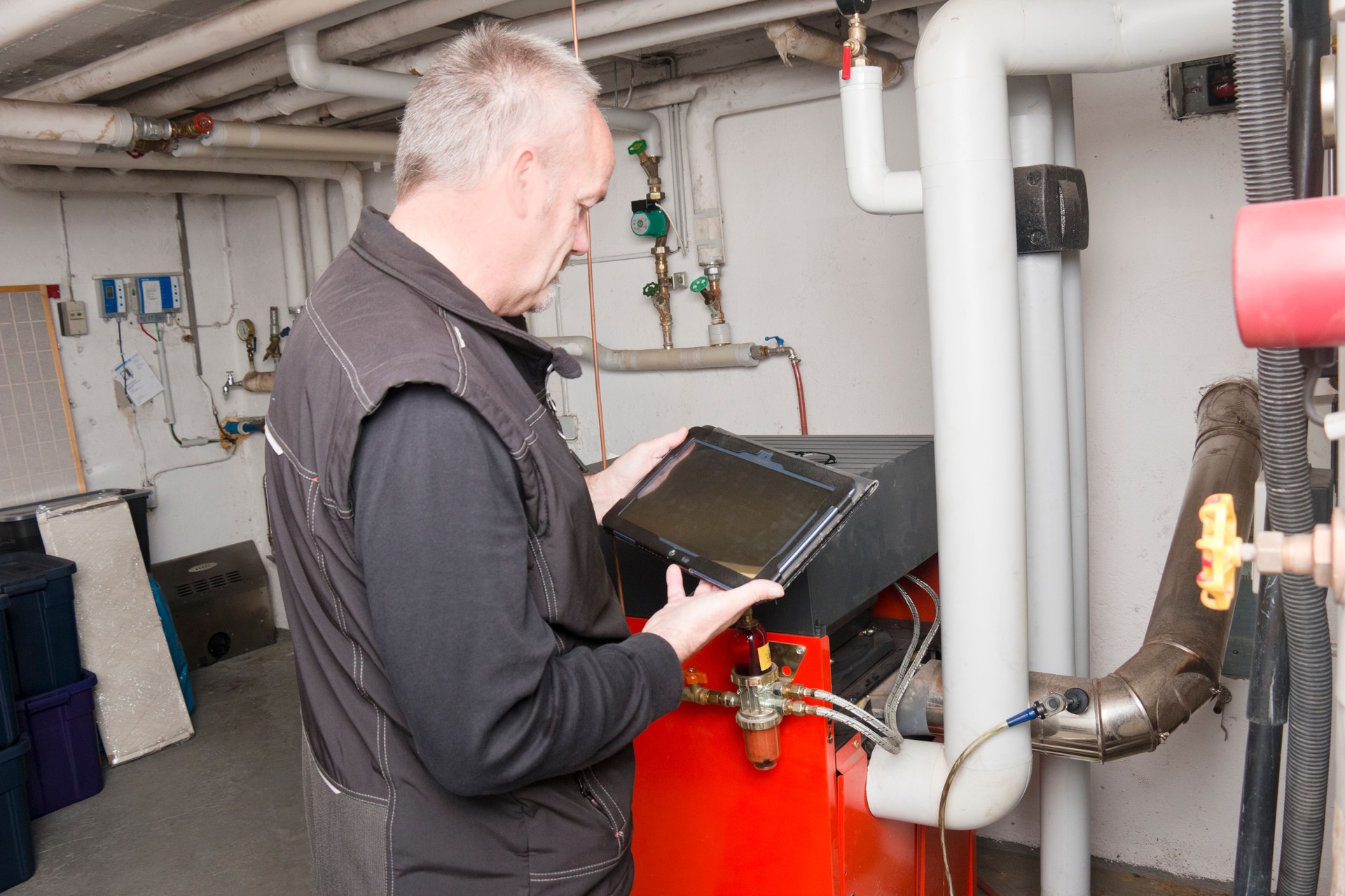Technician checking with an instrument of measurement the emissions of an old oil heater